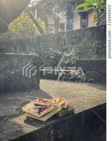Traditional balinese offerings to gods in Bali with flowers and aromatic sticks 118466922