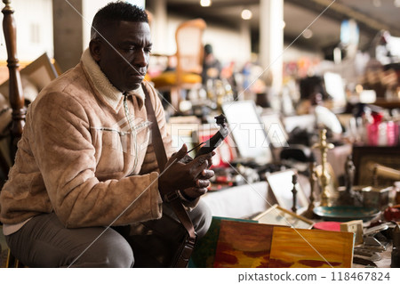 Man chooses antiques at a flea market Man chooses antiques at a flea market 118467824