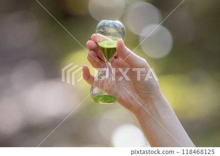 Person with hourglass in the forest 118468125