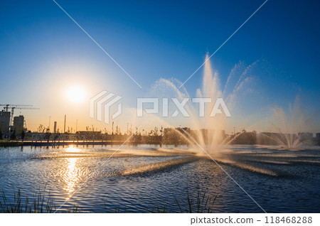 Large fountains illuminated by sunlight in the city park 118468288