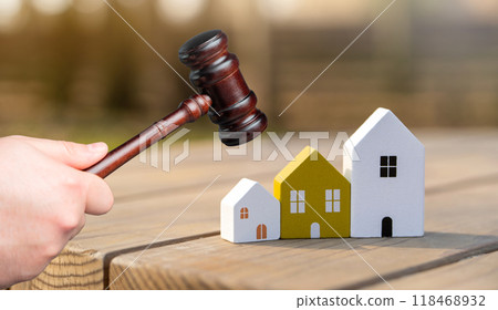 Judge's gavel near miniature wooden houses outdoors. Real estate court decisions. Property inheritance litigation. Establishment of ownership. 118468932