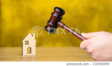 Judge's gavel near miniature wooden house. Real estate court decisions. Property inheritance litigation. Establishment of ownership. 118468940