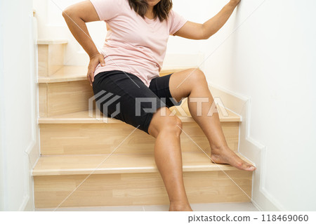 Asian lady fall down the stairs and pain at hip and waist because slippery surfaces. Asian lady fall down the stairs and pain at hip and waist because slippery surfaces. 118469060