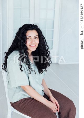 Curly brunette woman in summer clothes smiling Curly brunette woman in summer clothes smiling 118469487