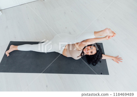 Relaxe harmonious beautiful brunette woman yoga instructor standing in anjaneyasana pose, 118469489