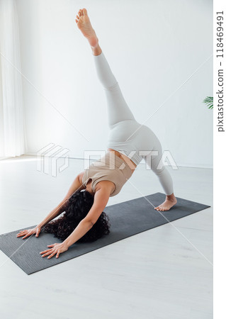 Side view of slim pretty positive young brunette woman doing Utthita parsvakonasana exercise, 118469491