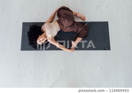 Side view of slim pretty positive young brunette woman doing Utthita parsvakonasana exercise, Side view of slim pretty positive young brunette woman doing Utthita parsvakonasana exercise, 118469493