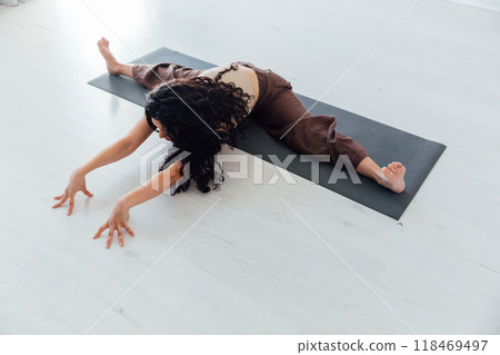 brunette woman doing gymnastics yoga asana brunette woman doing gymnastics yoga asana 118469497