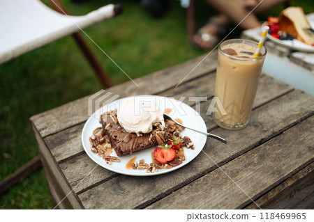 Basic homemade brownie or chocolate cake. Scoop of ice cream on a fresh stack of fresh brownies. Cold brew latte with milk and ice. Basic homemade brownie or chocolate cake. Scoop of ice cream on a fresh stack of fresh brownies. Cold brew latte with milk and ice. 118469965