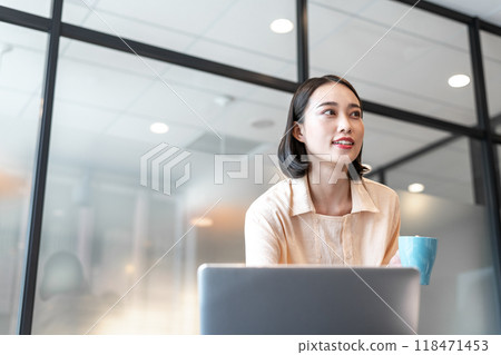 一位女士在休息時一邊看著電腦一邊交談 118471453