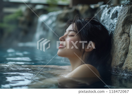 Travel image: A woman relaxing in an open-air bath 118472067