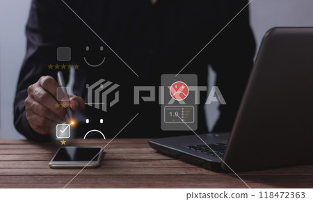 Customer Review, Young man with laptop and smartphone mobile hand holding a pen touching to review Customer Review, Young man with laptop and smartphone mobile hand holding a pen touching to review 118472363