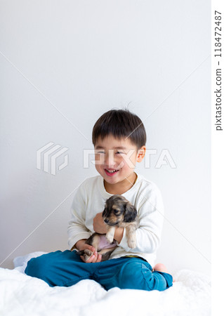 Boy holding a Kaninchen Dachshund puppy Boy holding a Kaninchen Dachshund puppy 118472487