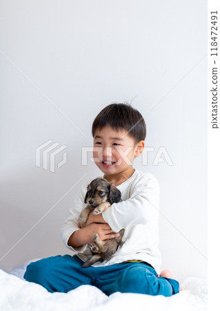 一個男孩抱著一隻 Kaninhen 臘腸狗小狗 118472491