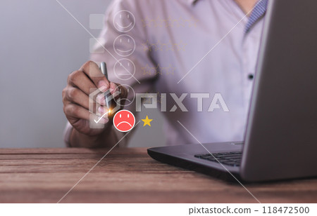 Customer Review, Young man uses laptop hand with pen touching to review and gives 1 star 118472500