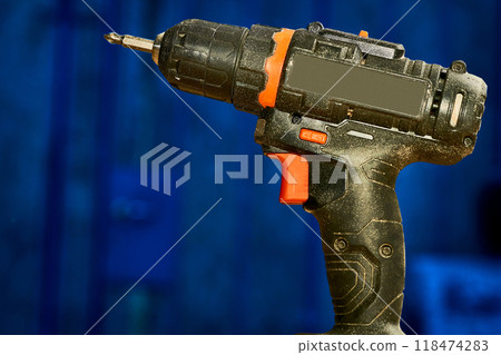 Electric drill,screwdriver on a blue dark workshop Electric drill,screwdriver on a blue dark workshop 118474283