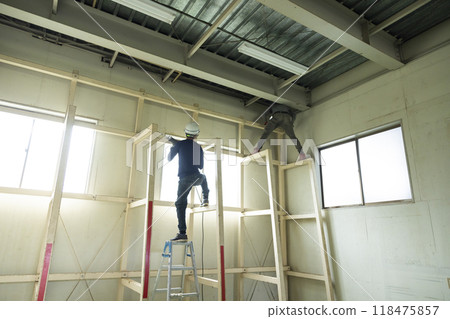 Workers dismantling steel beams 118475857