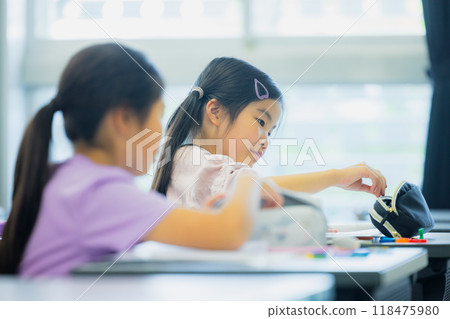 Elementary school students taking lessons in a classroom Elementary school students taking lessons in a classroom 118475980