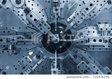 Close up the coil spring making machine in light blue scene. 118476296