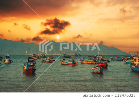Vietnamese traditional fishing boats at seaport against the backdrop of a beautiful sunset in summer Vietnamese traditional fishing boats at seaport against the backdrop of a beautiful sunset in summer 118476325
