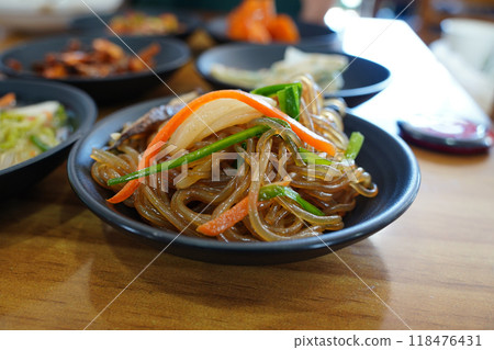 Korean dish made by mixing noodles with thin slices of stir-fried various vegetables, meat 118476431