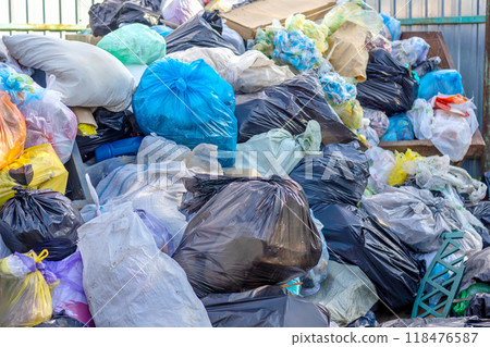 Garbage dump with many dirty colorful bags has not been removed for long time. Disposal problem, plastic waste 118476587