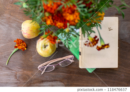 Books, eyeglasses and apples on wooden table on veranda with fall bouquet. Top view. Autumn still life. Nostalgia for the past. time of old age Books, eyeglasses and apples on wooden table on veranda with fall bouquet. Top view. Autumn still life. Nostalgia for the past. time of old age 118476637