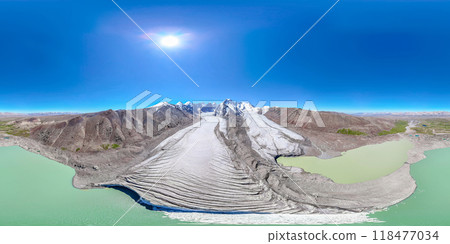 The Kyzyl-Asker glacier in Kyrgyzstan offers a stunning 360-degree panorama, with a turquoise lake at the foot and a bright blue sky above it. The snow-capped peaks of the mountains rise majestically The Kyzyl-Asker glacier in Kyrgyzstan offers a stunning 360-degree panorama, with a turquoise lake at the foot and a bright blue sky above it. The snow-capped peaks of the mountains rise majestically 118477034