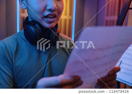 Singing Enthusiast Reading Lyrics During Recording Session 118478426