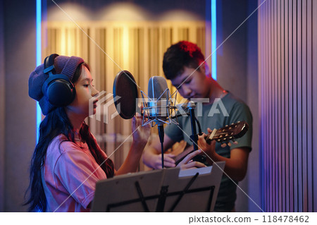 Recording Vocals in Music Studio with Acoustic Guitar Player 118478462