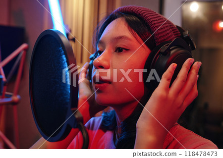 Recording Song in Professional Studio Wearing Headphones 118478473