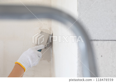 The finisher levels the corner using an angle trowel. 118478559