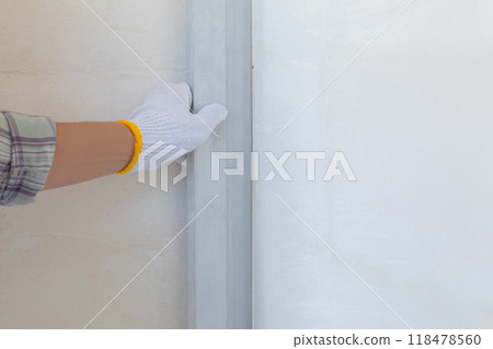 The master applies a rule to align the corner of the wall. The master applies a rule to align the corner of the wall. 118478560