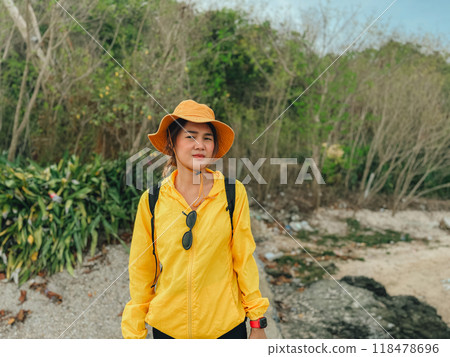 Woman in yellow outdoor hat and outfits, walk and exploring the beach. 118478696