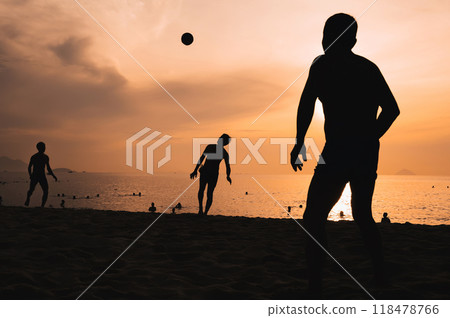 Silhouettes of Asian men playing beach soccer on beach by the sea at sunset 118478766