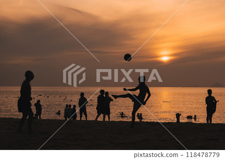 Silhouettes of a group of Asian men playing traditional beach soccer on a beach by sea at sunset Silhouettes of a group of Asian men playing traditional beach soccer on a beach by sea at sunset 118478779