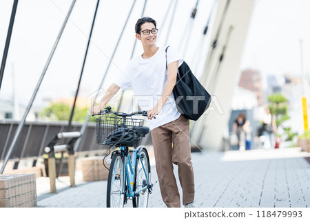 Young man pushing a bicycle Young man pushing a bicycle 118479993