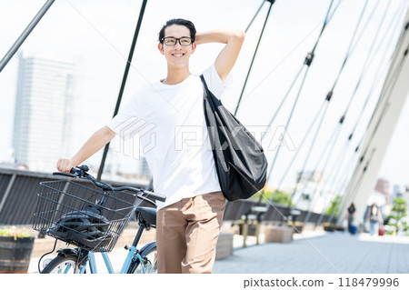 Young man pushing a bicycle Young man pushing a bicycle 118479996