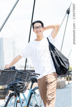 Young man pushing a bicycle 118479997