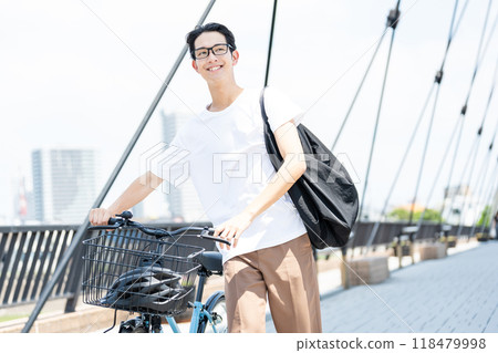 Young man commuting by bicycle 118479998