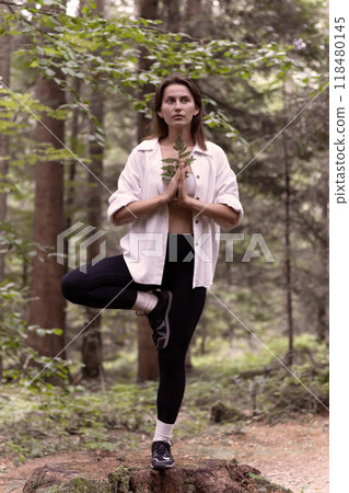 young woman in the forest standing the tree yoga pose young woman in the forest standing the tree yoga pose 118480145