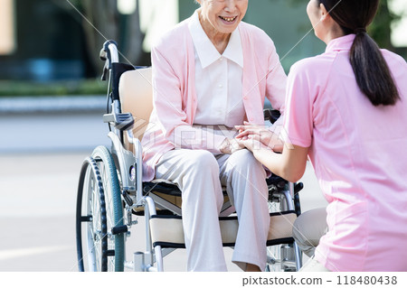 Senior woman in a wheelchair and her caregiver 118480438