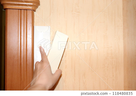 A woman's hand with a handset presses the door opening button on the intercom A woman's hand with a handset presses the door opening button on the intercom 118480835