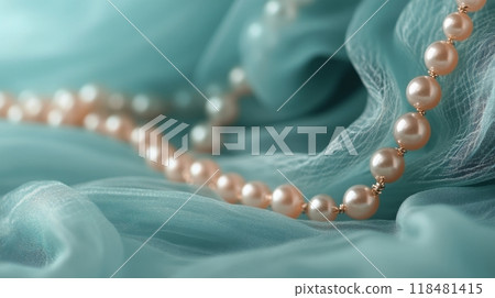 Elegant pearl necklace draped over soft teal fabric creating a luxurious visual display Elegant pearl necklace draped over soft teal fabric creating a luxurious visual display 118481415