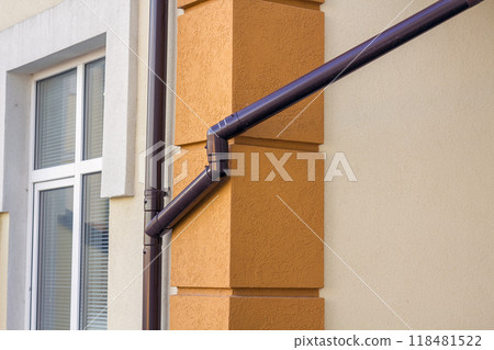 Roofing steel gutter rain system on building corner on light copy space background. Roofing, construction, drainage pipes installation concept. 118481522