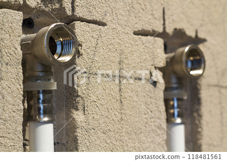 Water pipes made of polypropylene in the wall, plumbing in the house. Installation of sewer pipes in a bathroom of an apartment interior during renovation works. Gray plastic drain pipe for used water 118481561