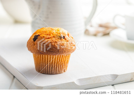 Sweet muffin cakes on cutting board on white table. Sweet muffin cakes on cutting board on white table. 118481651