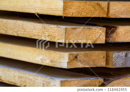 Close-up of neatly piled stack of natural brown rough wooden boards. Industrial timber for carpentry, building, repairing and furniture. 118481955