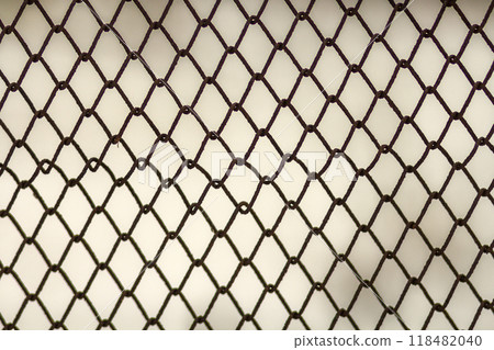 Background and texture for design. Abstract chain link fence texture against grungy gray color wall. 118482040