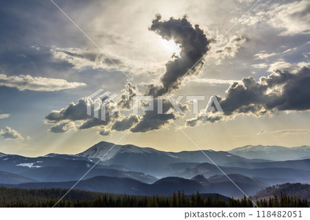 Beautiful fantastic view of blue sky with bright white clouds in mysterious shape of question over magnificent mountain rage with snow covered tops and evergreen pine forest. Beauty of nature concept. 118482051